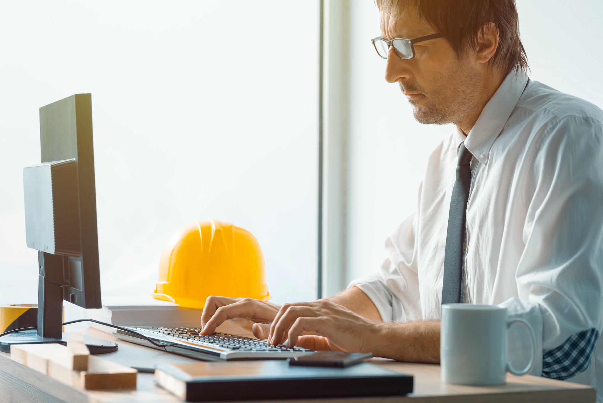 Construction engineer working on desktop computer using CAD soft